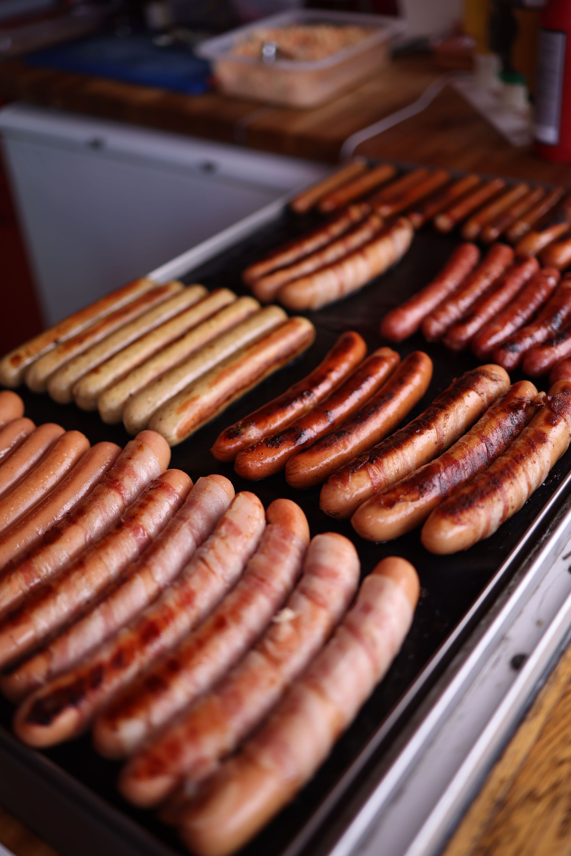 Delicious assortment of grilled sausages cooked indoors on a kitchen griddle. Ideal for barbecue lovers.